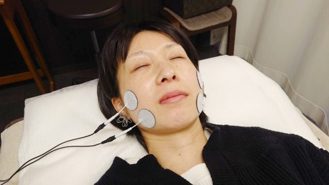 EMSという心地よい機械の電気刺激で筋肉を刺激し、表情筋をリフトアップさせている画像。